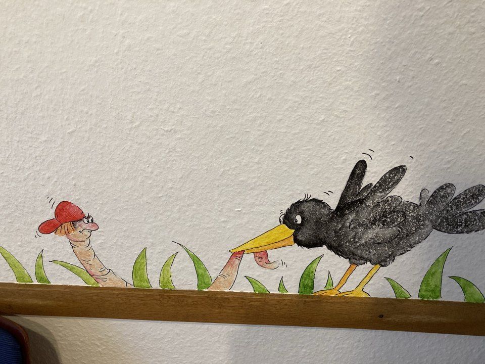 Rabe und Regenwurm auf einer Tapete in der Kinderarztpraxis Börchers
