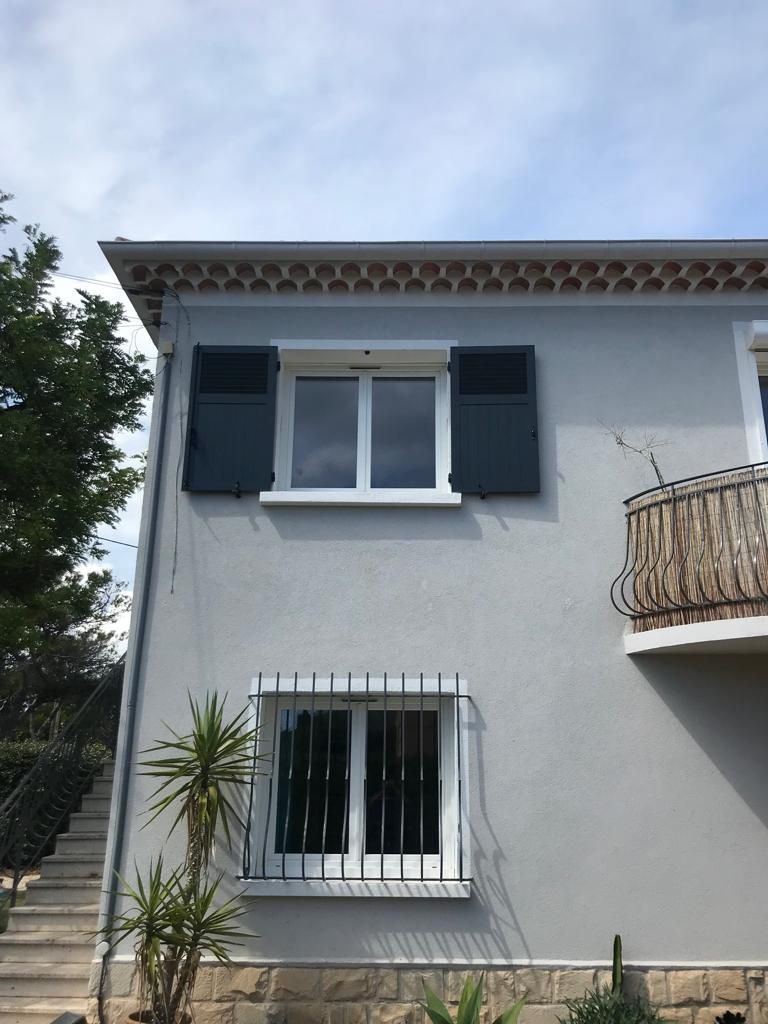 Triptyque de fenêtres à petits carreaux et volets battants gris foncé