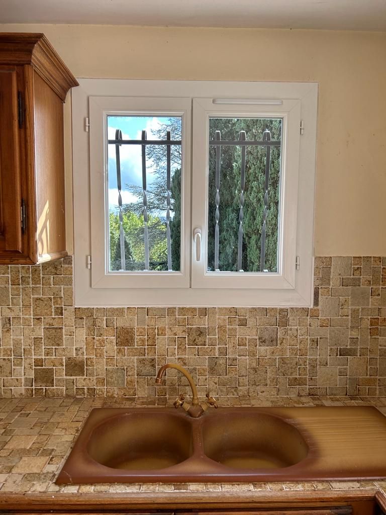 Fenêtre en PVC blanche au dessus d'un évier de cuisine