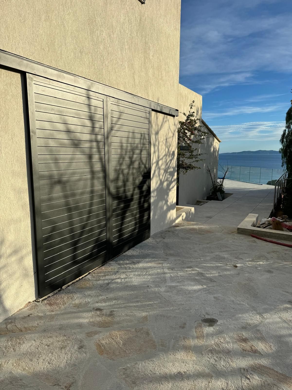 Maison au crépi rose et volets battants blancs