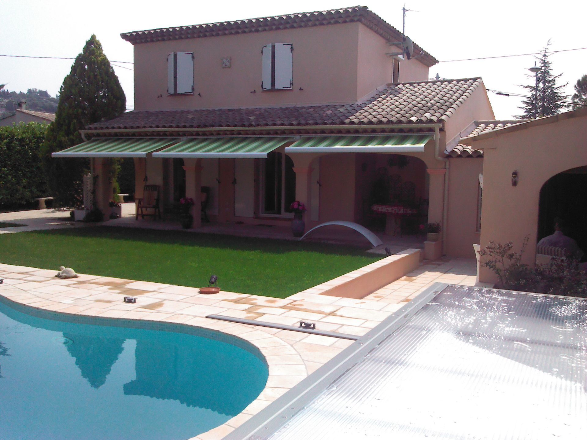 Façade de maison et stores enrouleurs à rayures vertes