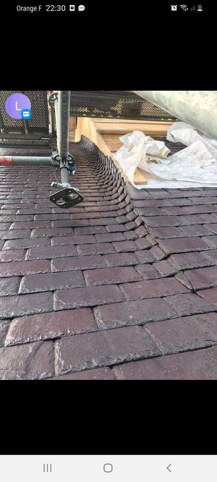 Gros plan d'un toit en bardeaux avec une structure qui s'étend à partir de celui-ci.