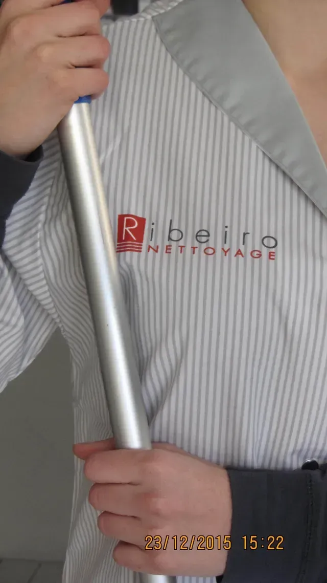 Logo de l'entreprise Ribeiro Nettoyage sur l'uniforme d'une femme de ménage