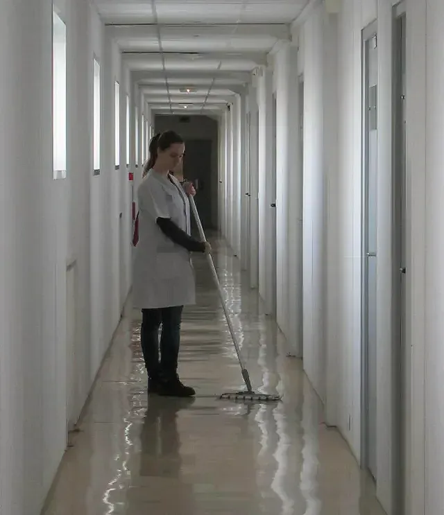 Une femme nettoie un couloir