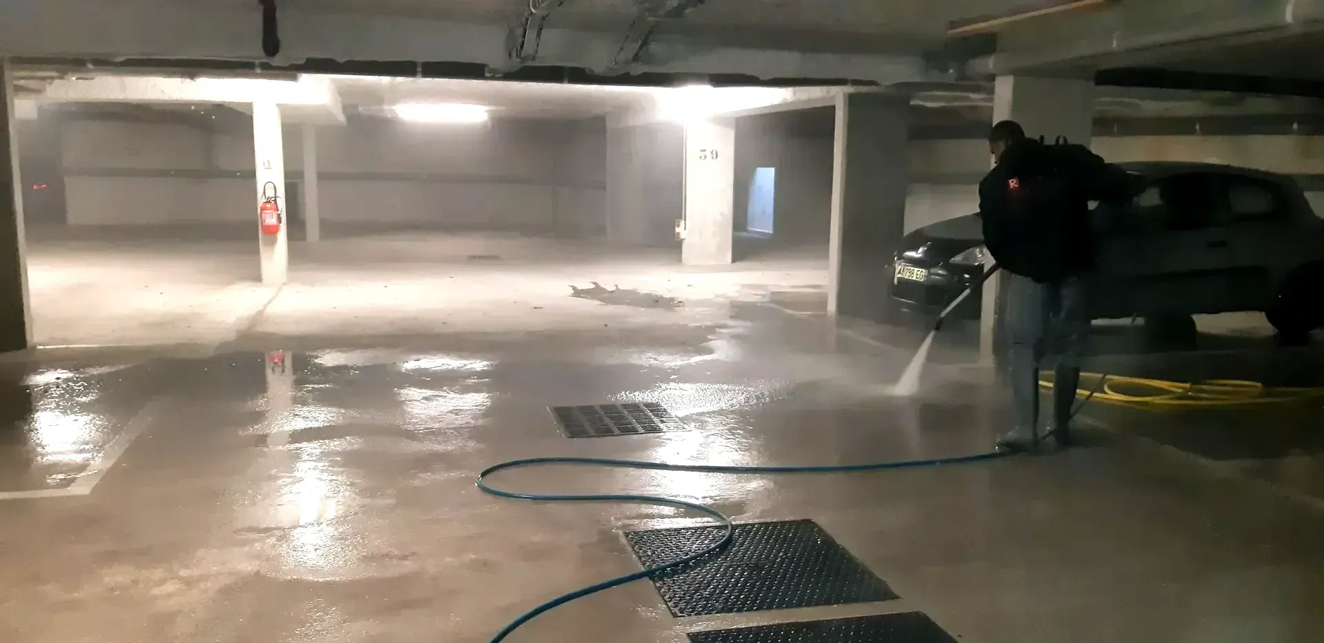 Un homme nettoie le sol d'un parking
