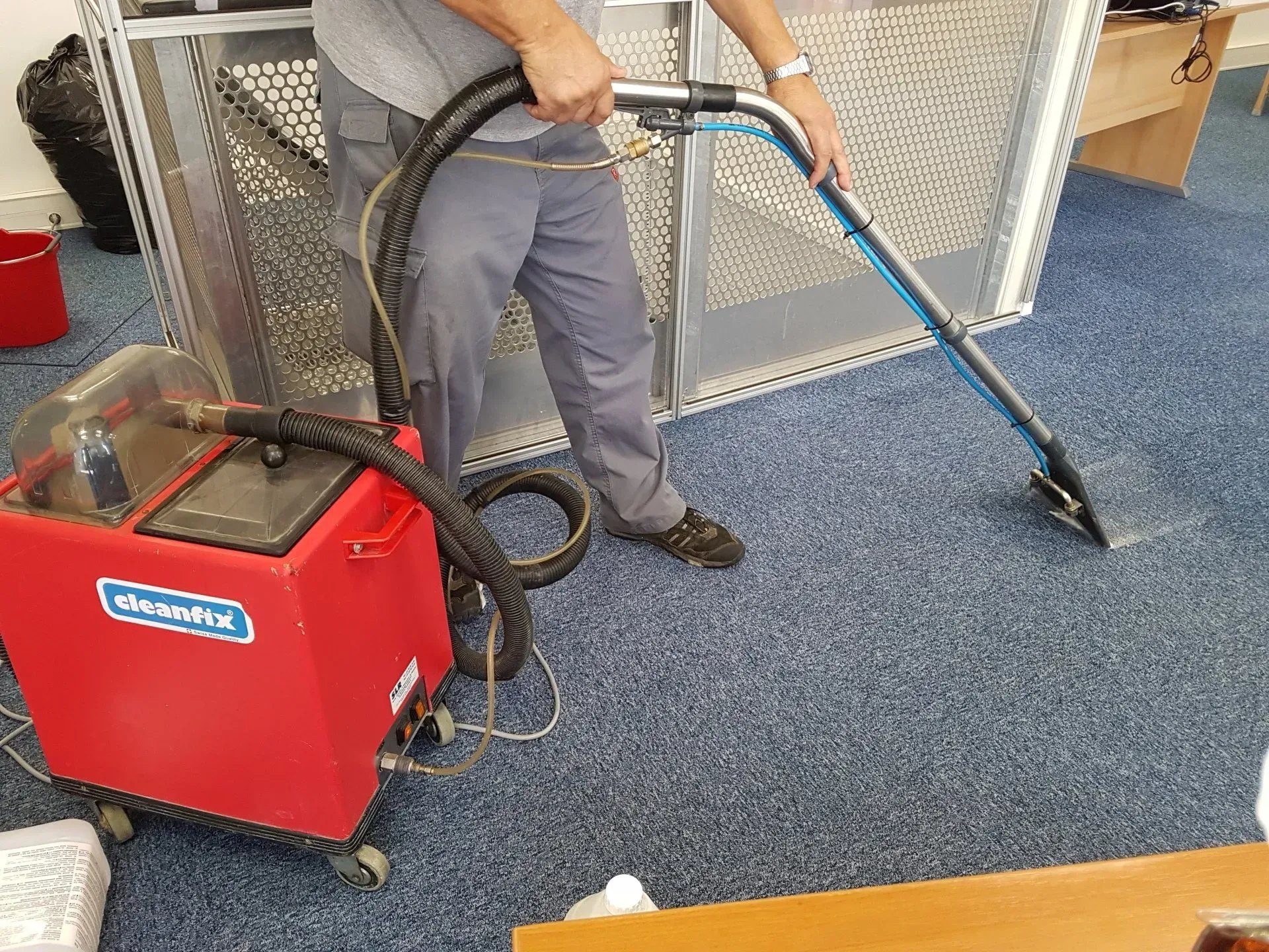 Un homme nettoie une moquette