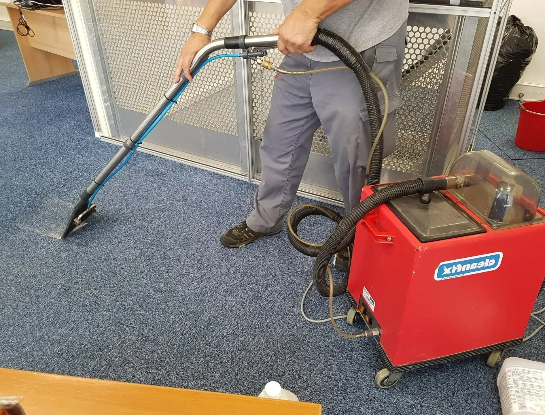 Un homme nettoie une moquette avec la technique de l'injection