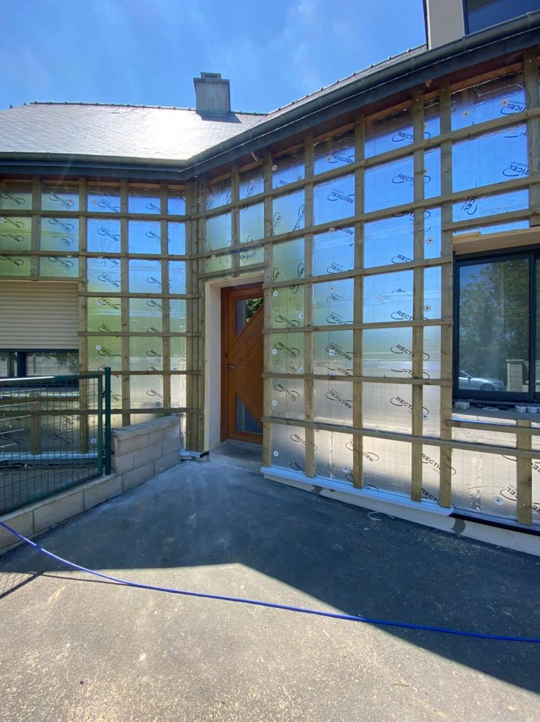 Ossature en bois avec des panneaux isolants installés sur le mur extérieur d'un bâtiment.