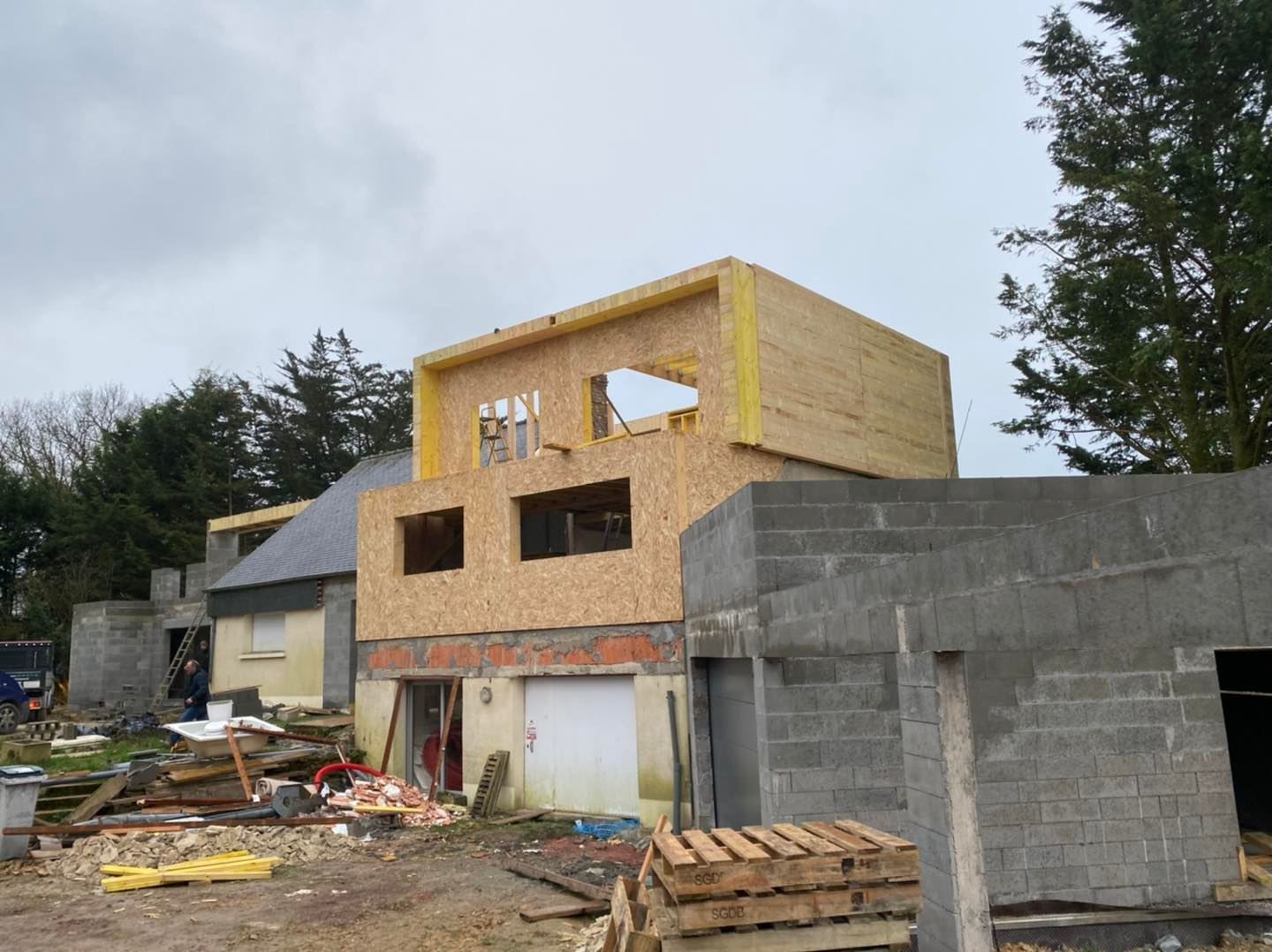 Un chantier de construction où une nouvelle structure à ossature bois est ajoutée.