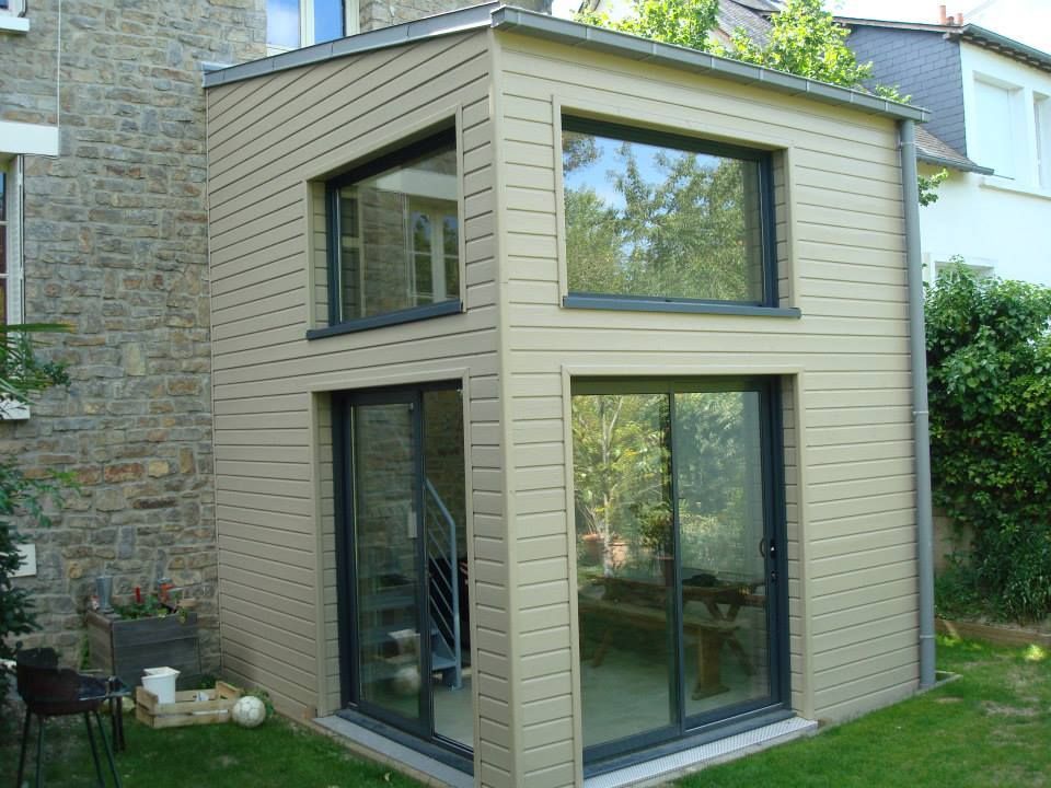 Une extension de maison avec un bardage clair.