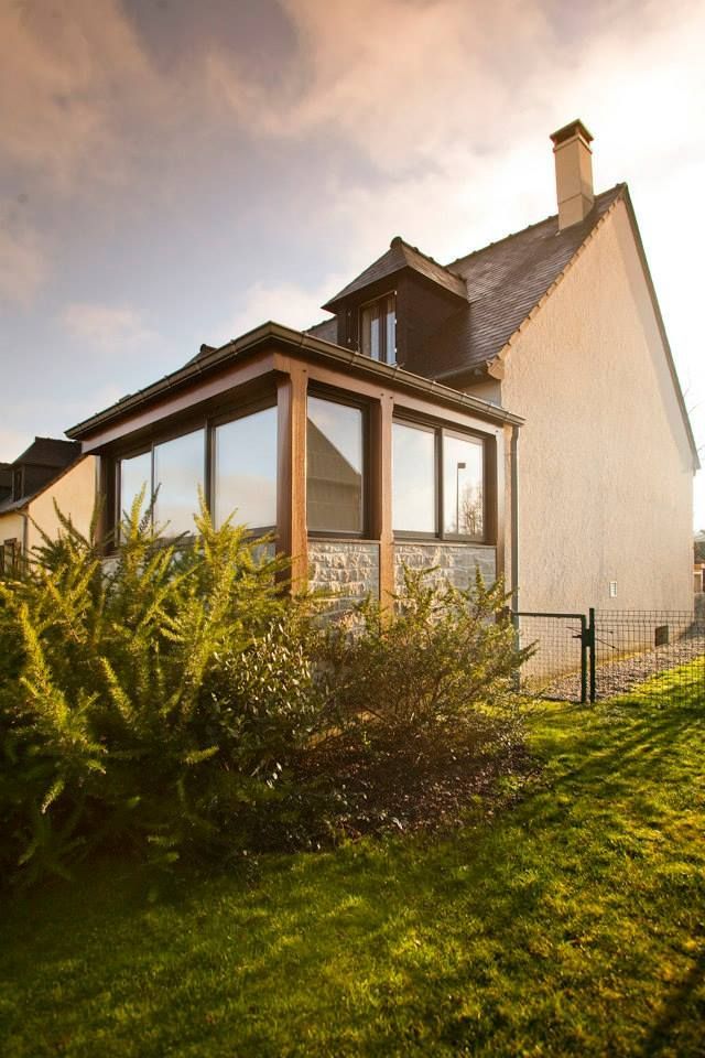 Une maison d'habitation avec une extension vitrée au rez-de-chaussée.
