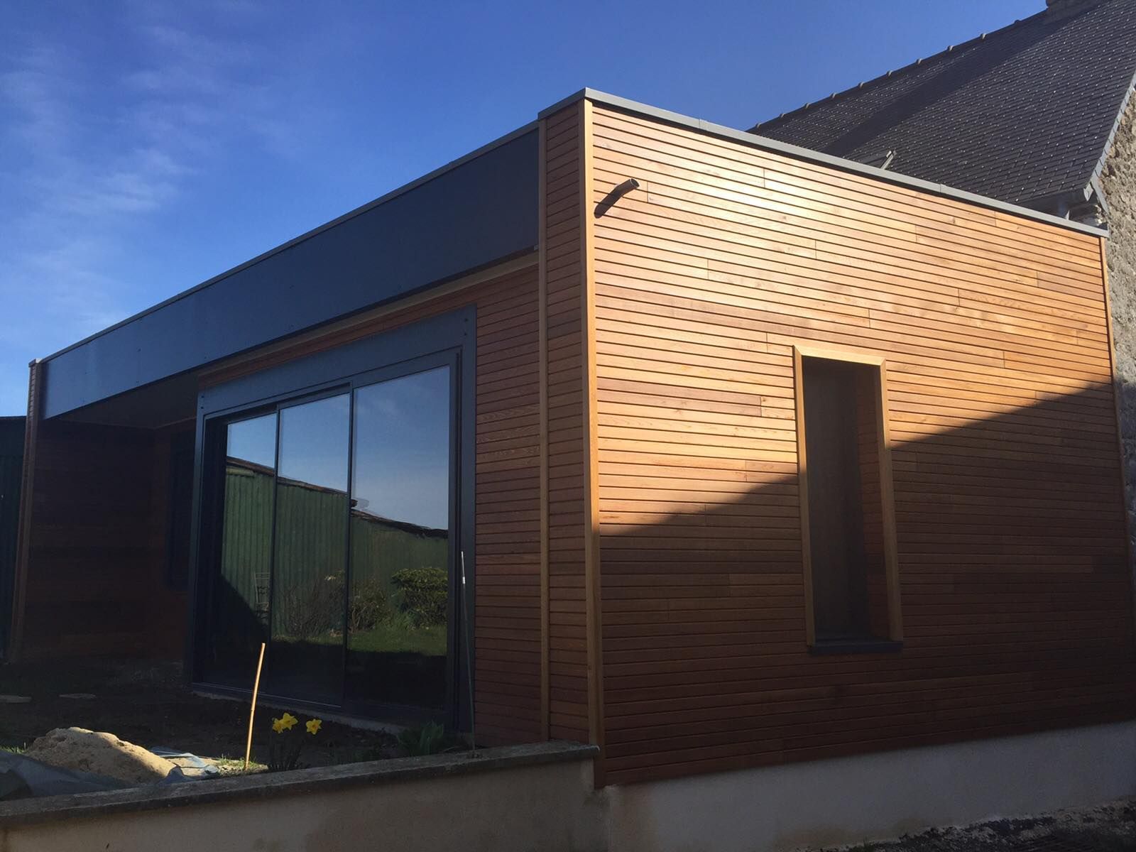 Extension de maison avec un bardage en bois.