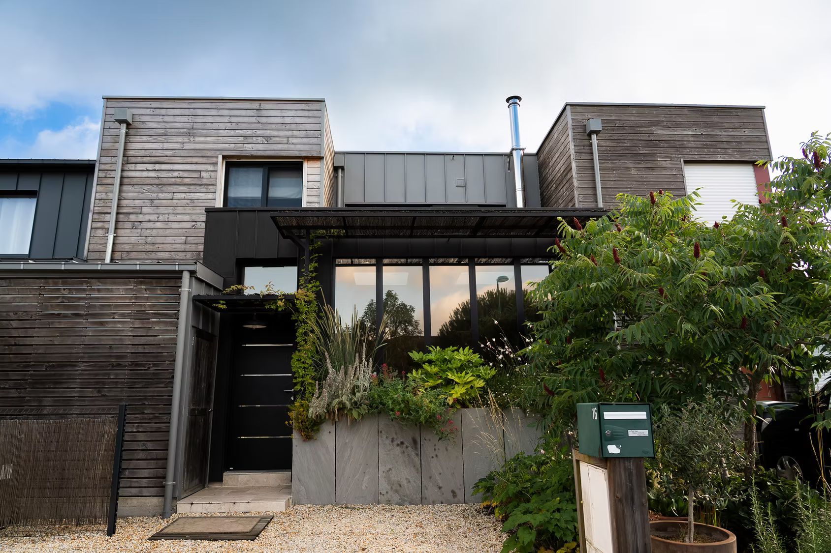 Une maison à deux étages avec un revêtement en bois.