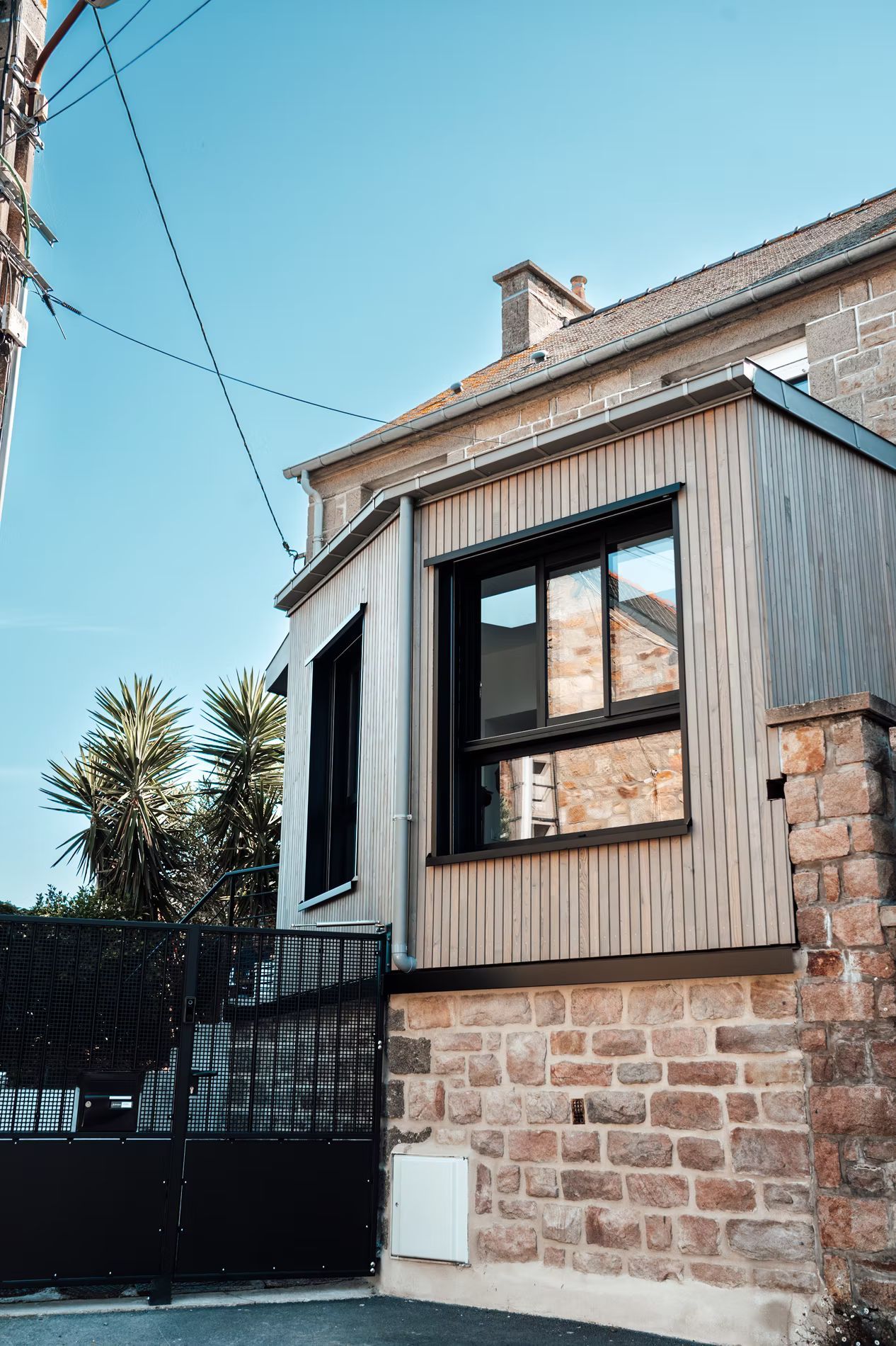 Une maison avec une extension en bois clair.