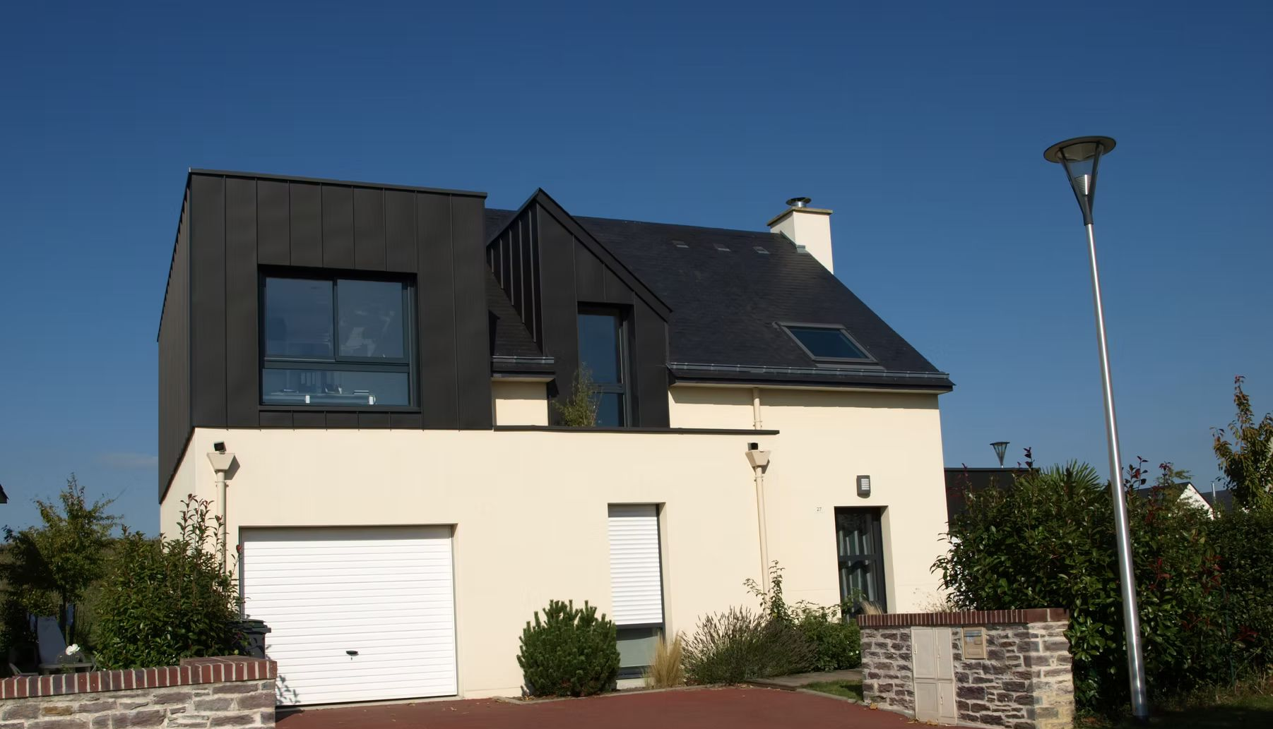 Un maison avec une surélévation en zinc.