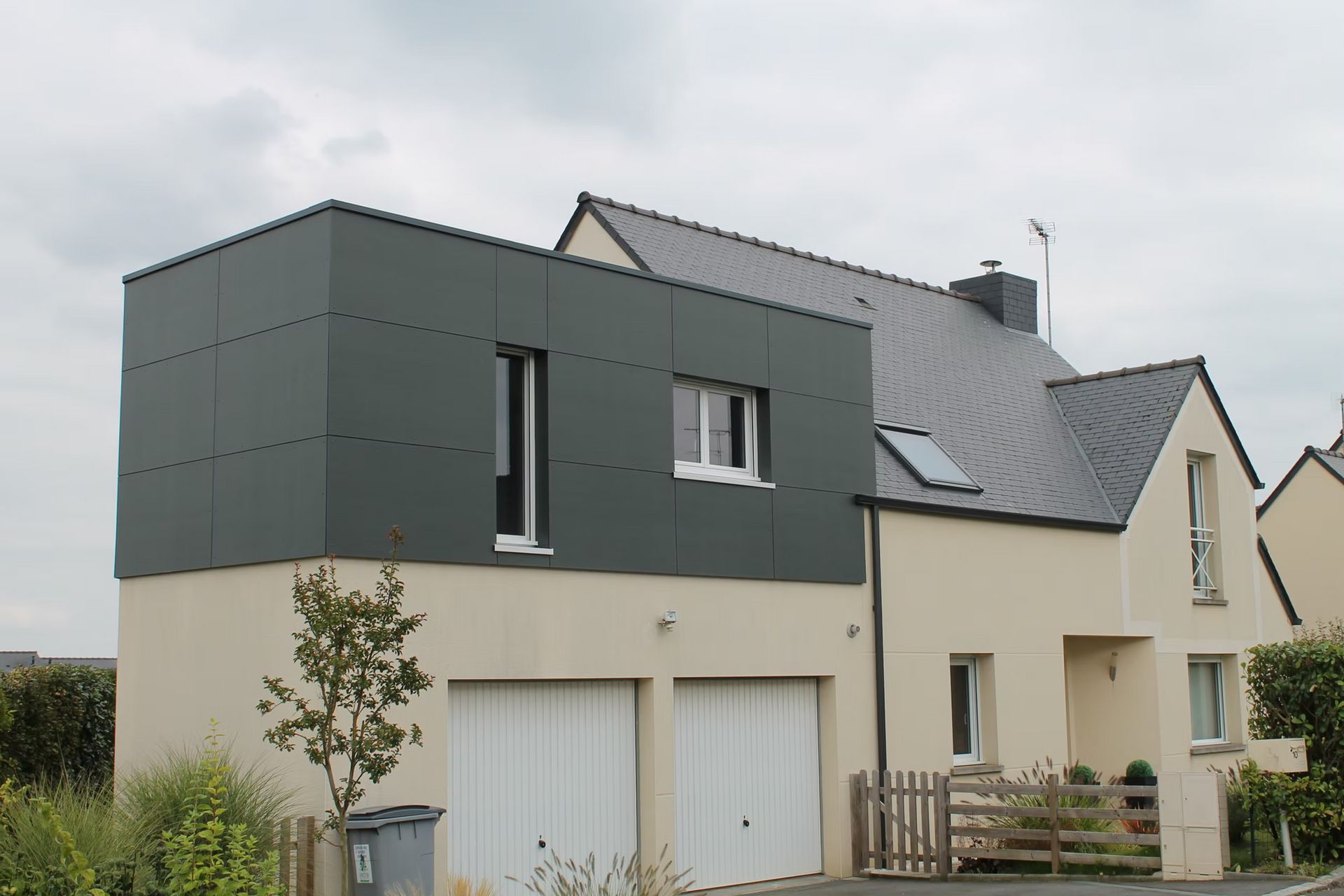 Une maison moderne et une extension à l'étage avec un toit plat.