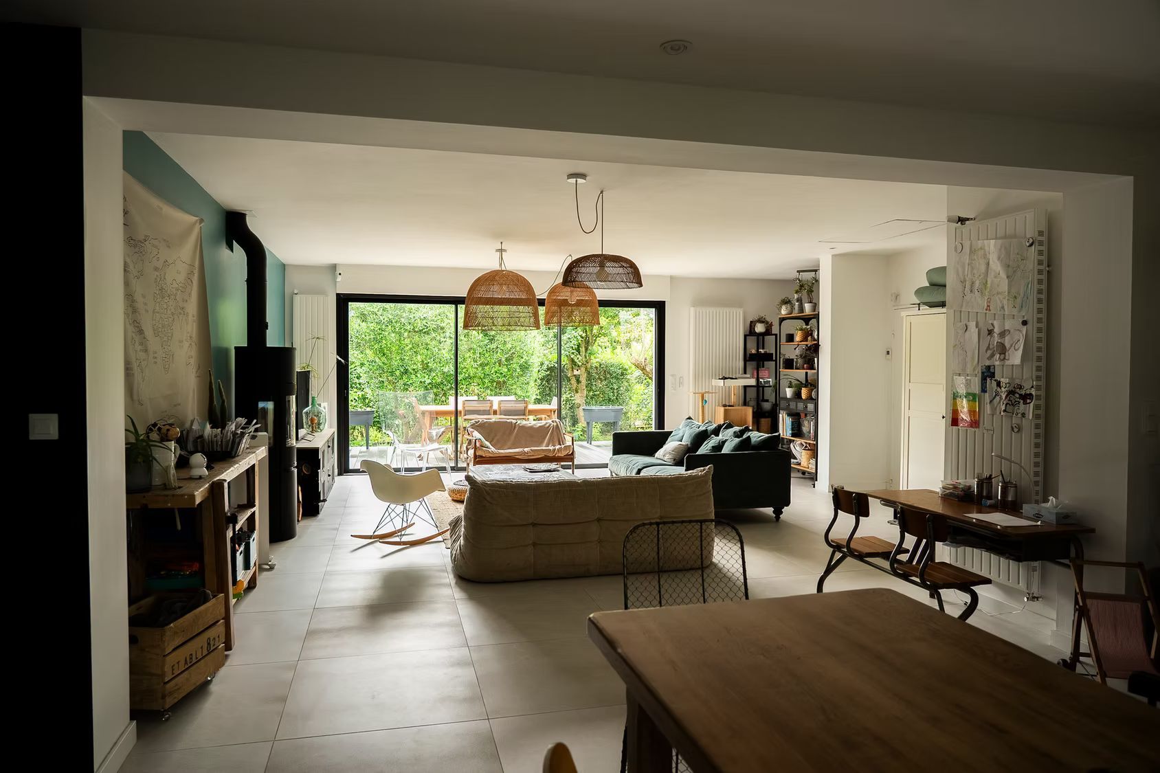 Un salon spacieux et une grande fenêtre donnant sur une cour.