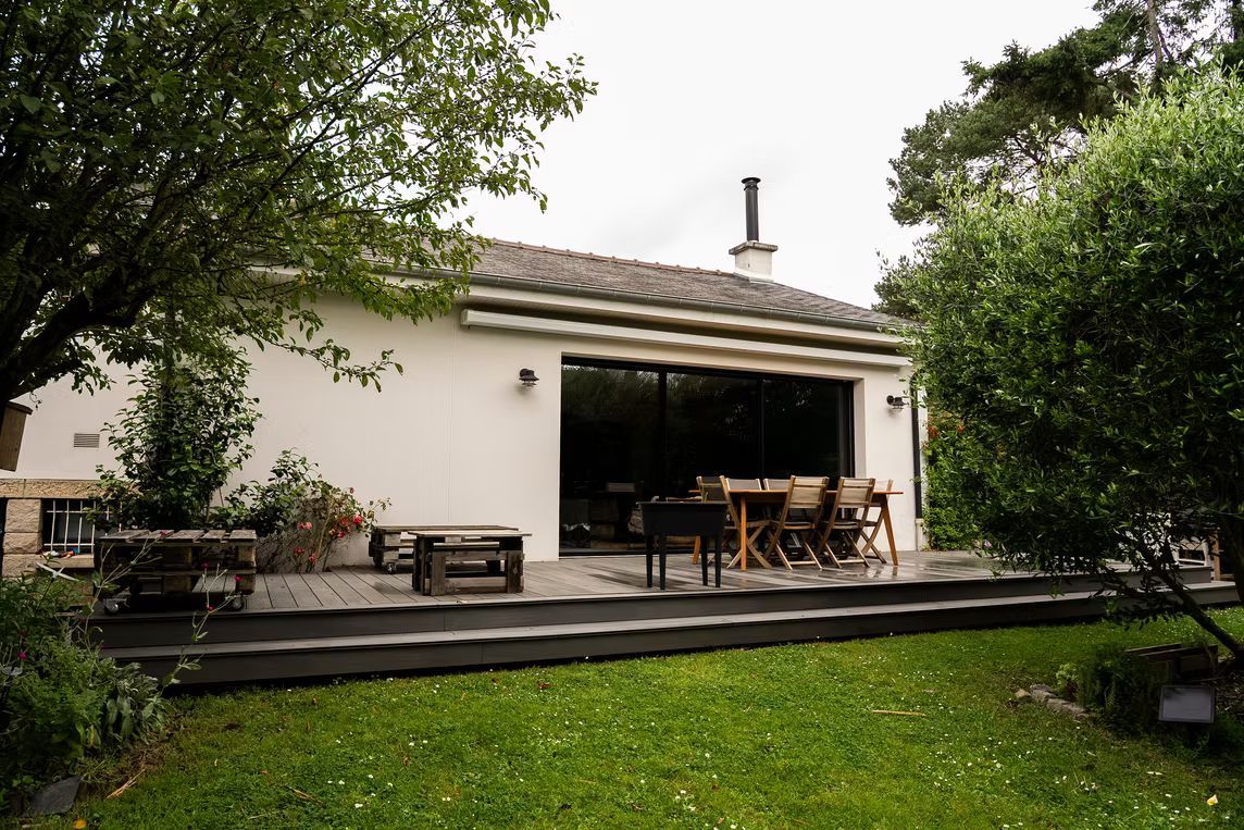 Une maison de plain-pied avec une terrasse en bois.