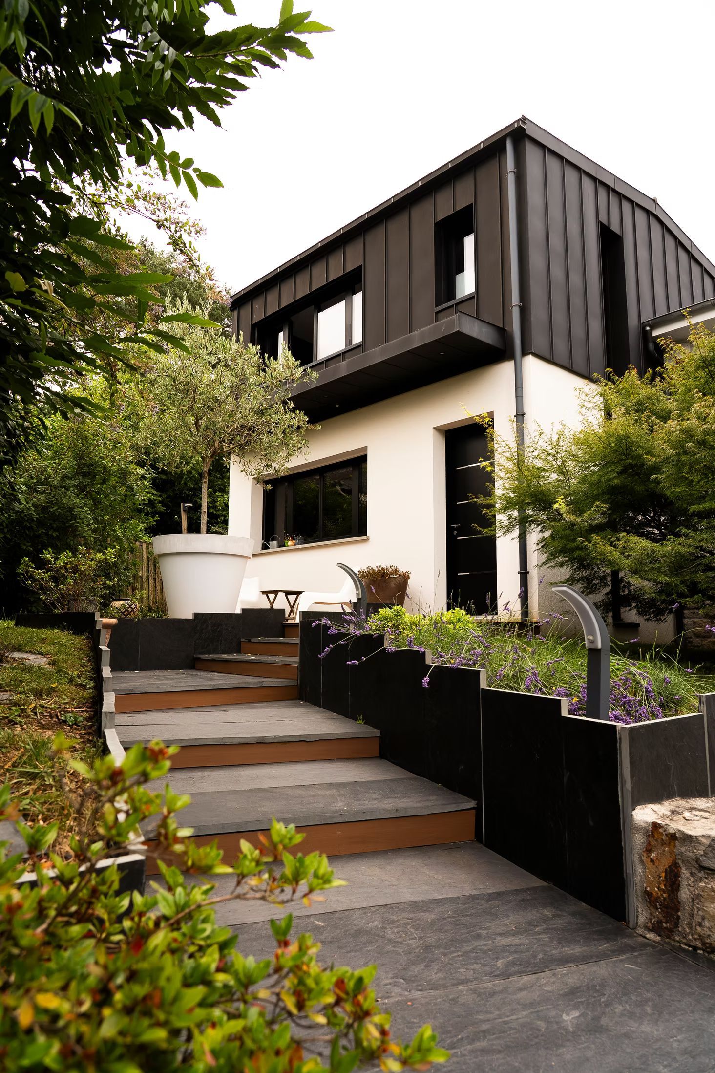 Une maison avec une surélévation et un extérieur aménagé.