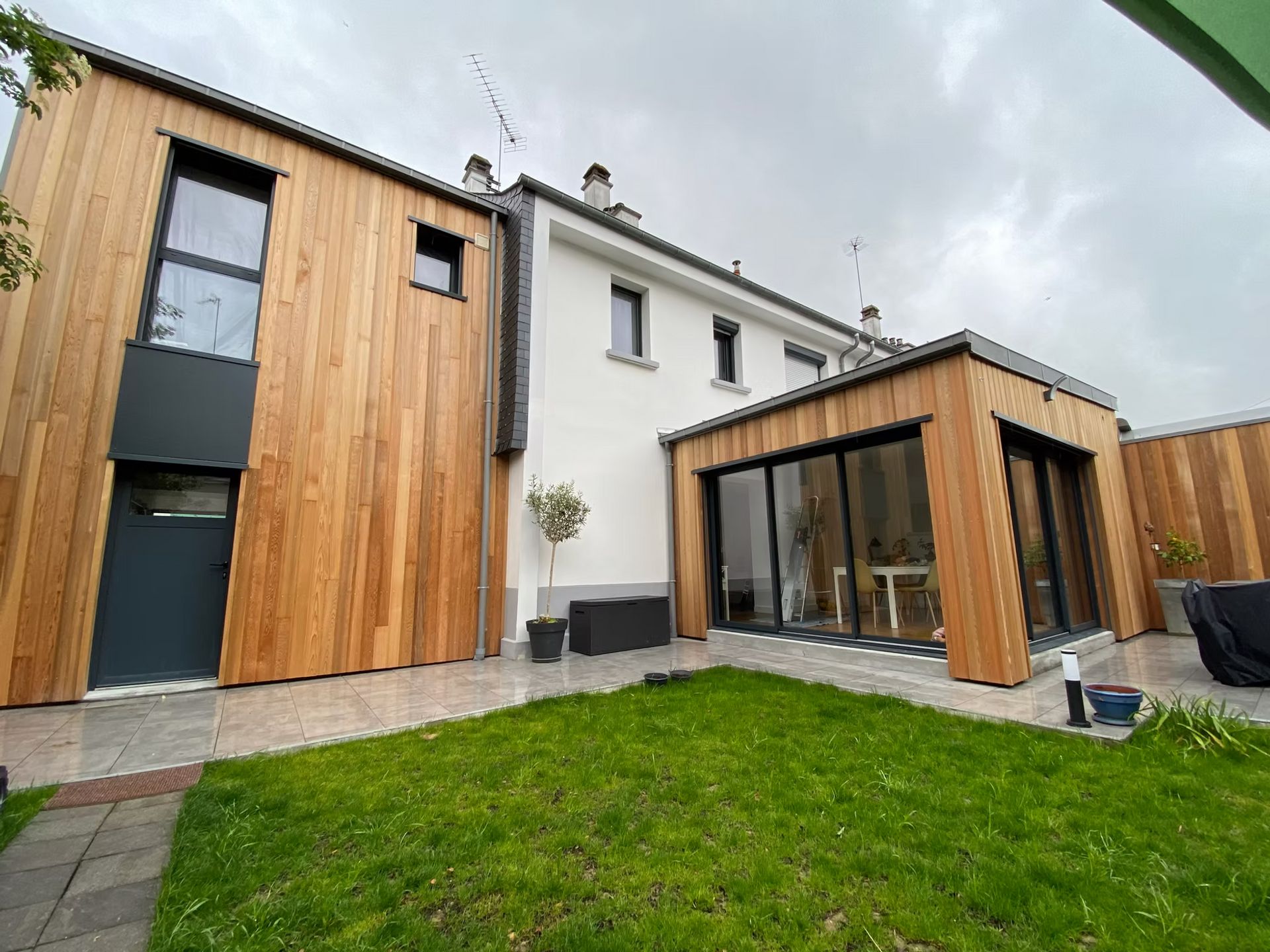 Une extension de maison moderne avec un bardage en bois.