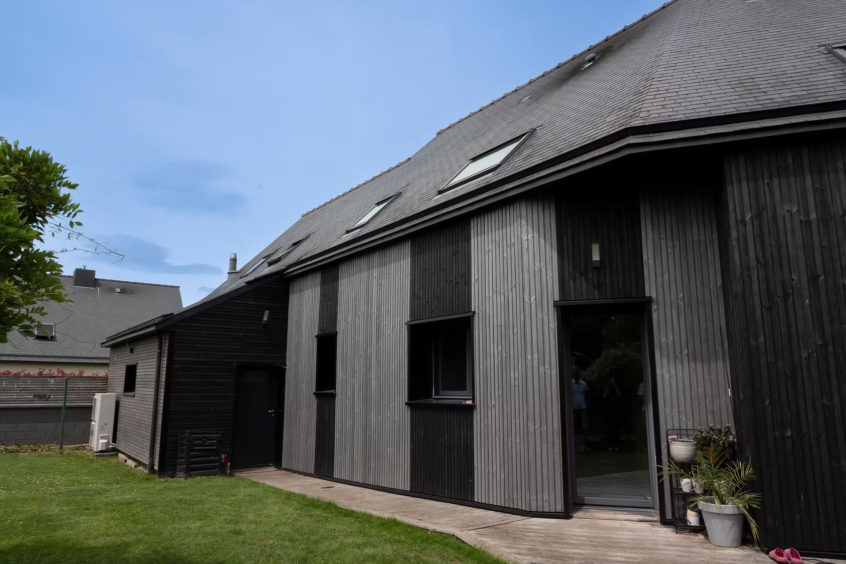 Une maison avec un bardage en bois noir.