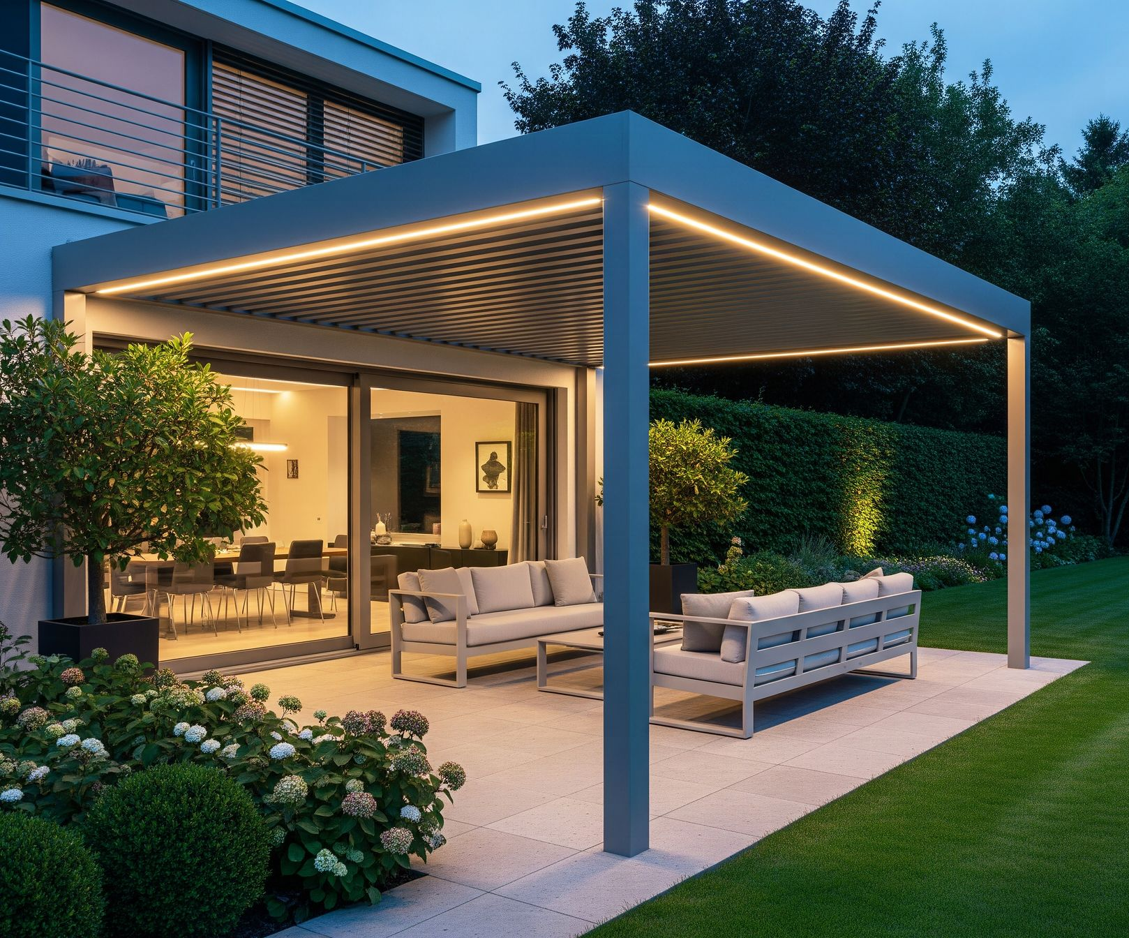 Patio extérieur moderne avec pergola grise, canapés et éclairage d'ambiance.