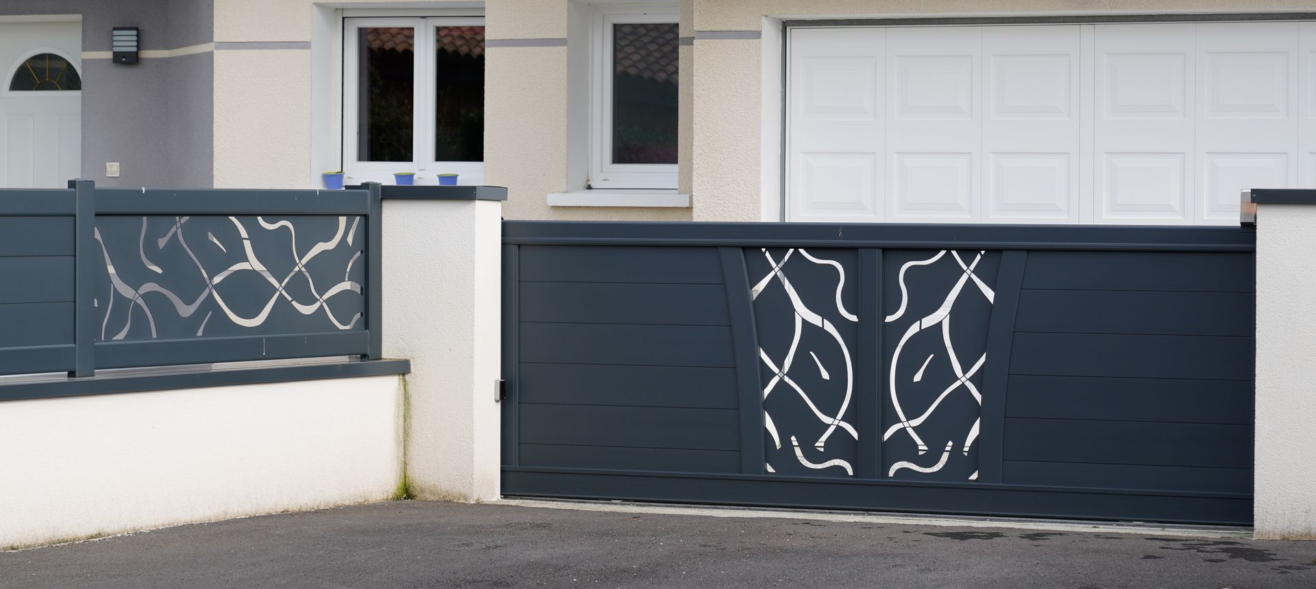 Portail et clôture décoratifs gris foncé.