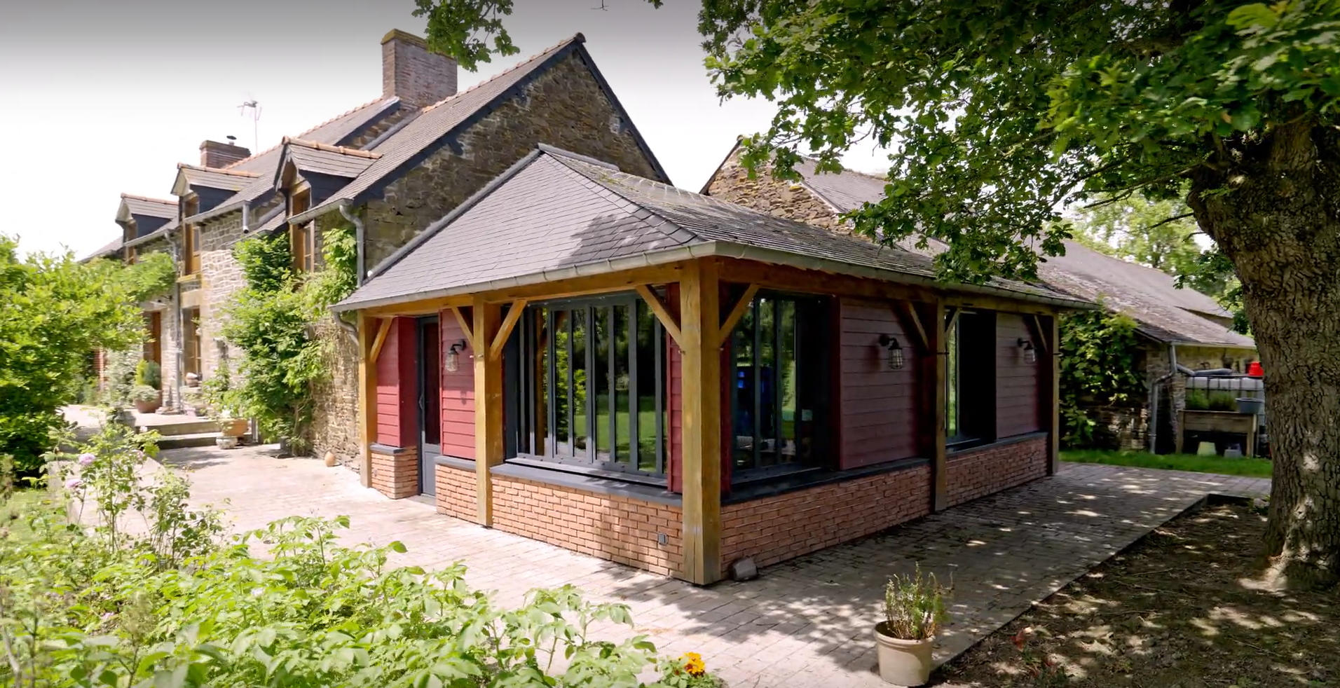 Maison en pierre avec une véranda à ossature bois.