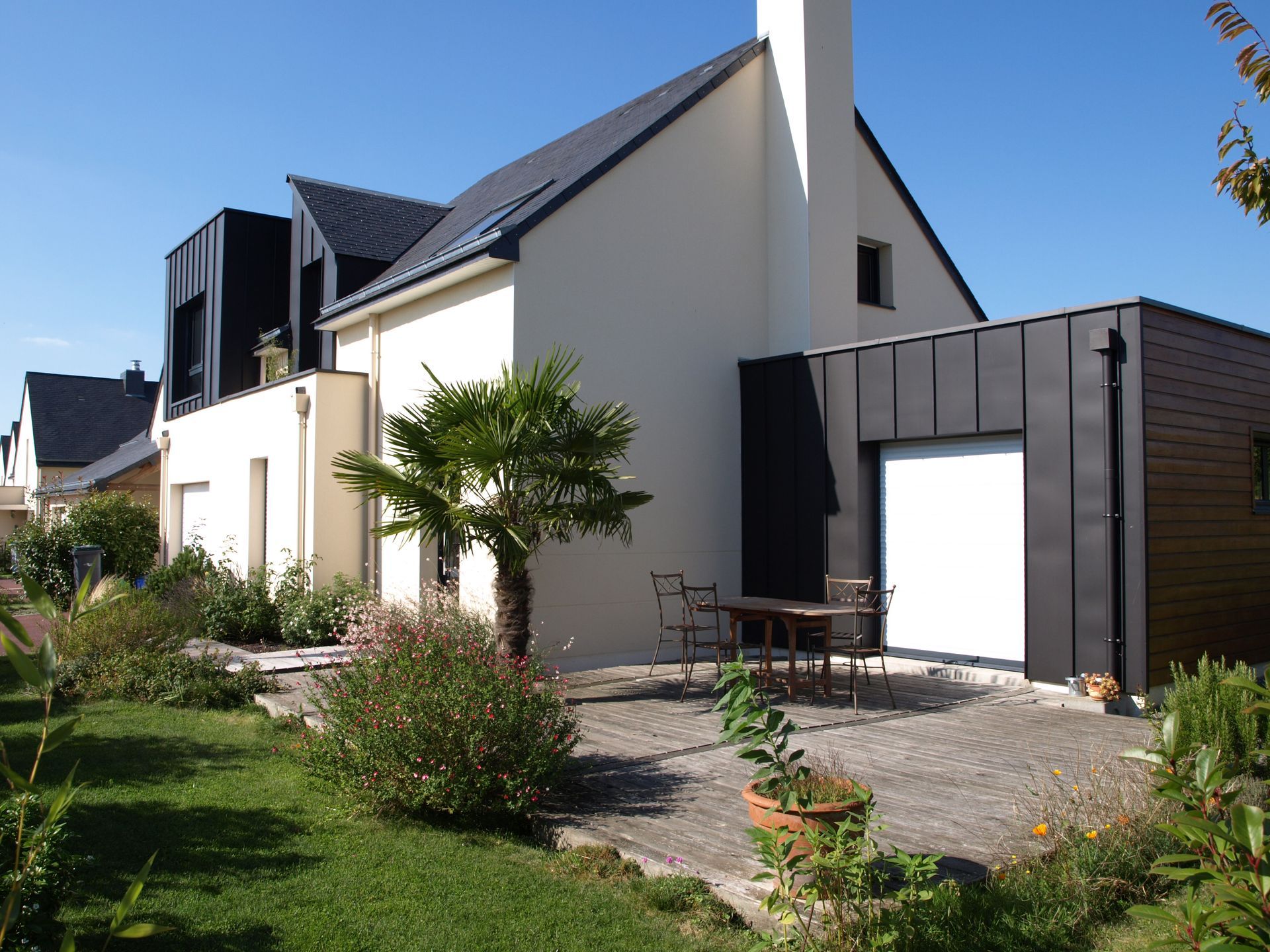 Une maison aux murs blancs avec une extension.