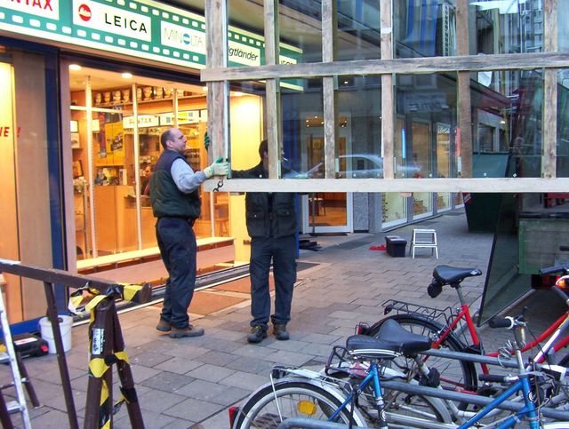 Zwei Arbeiter reparieren ein Glas