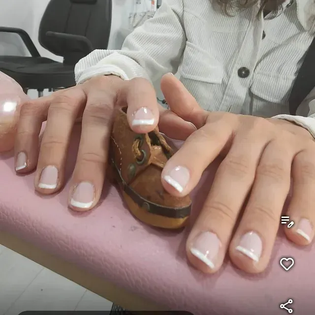 Una mujer sostiene un pequeño zapato marrón en sus manos.