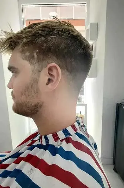 Un hombre con barba lleva una camisa a rayas