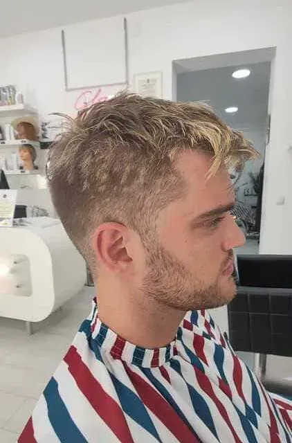 Un hombre con una camisa a rayas se está cortando el pelo.