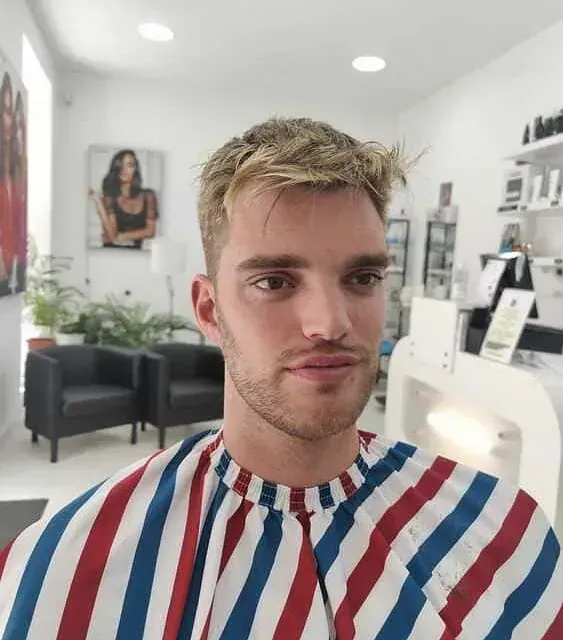 Un hombre lleva una capa de rayas rojas, blancas y azules.