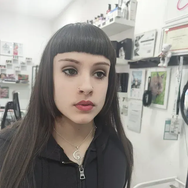 Una mujer que lleva un collar con la letra g.