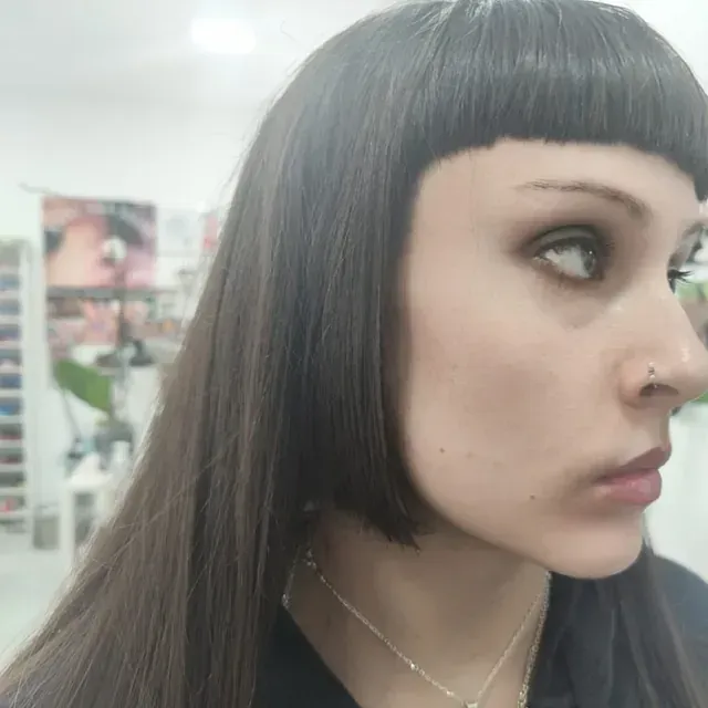 Un primer plano del rostro de una mujer con cabello largo y un anillo en la nariz.