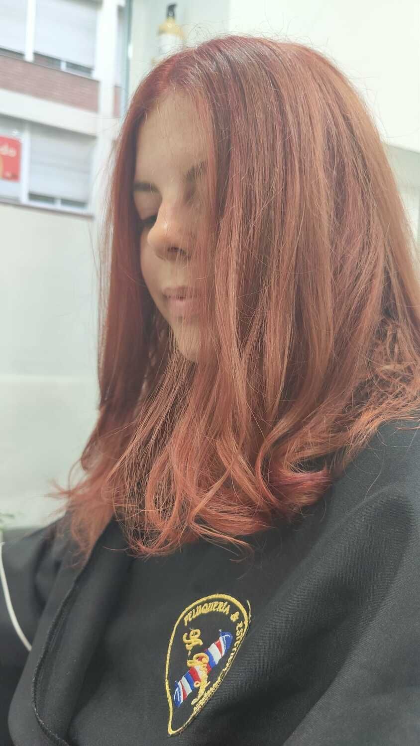 Una mujer pelirroja lleva una sudadera negra.