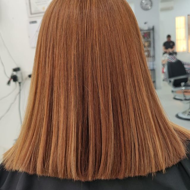 Se muestra la parte posterior del cabello de una mujer en un salón.