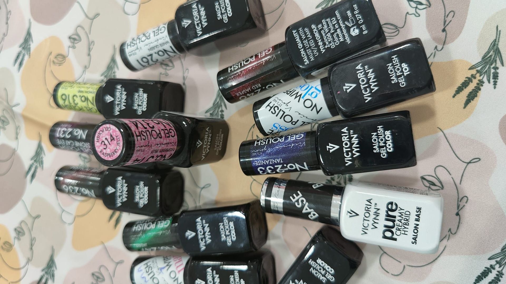 Un montón de botellas de esmalte de uñas están sobre una mesa.