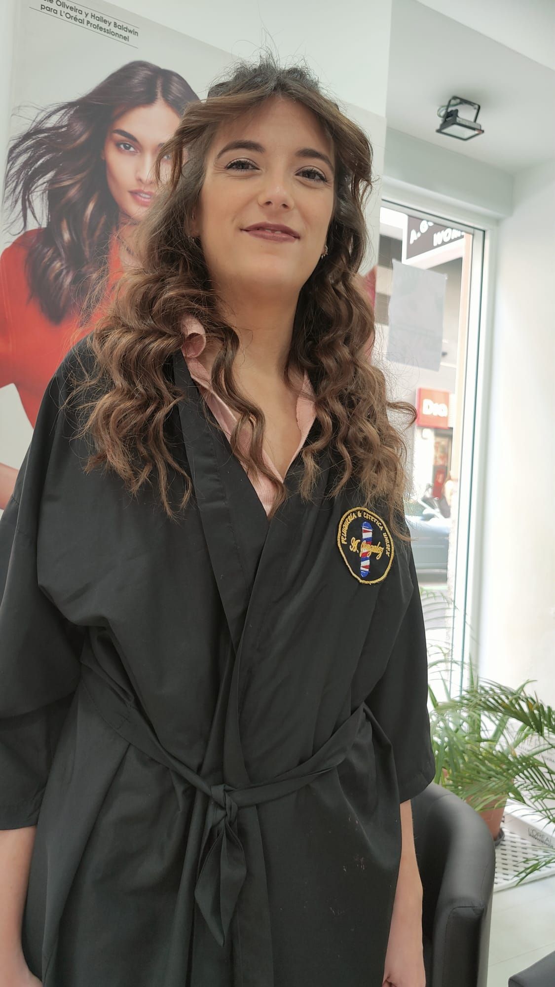 Una mujer con una túnica negra está de pie en un salón.