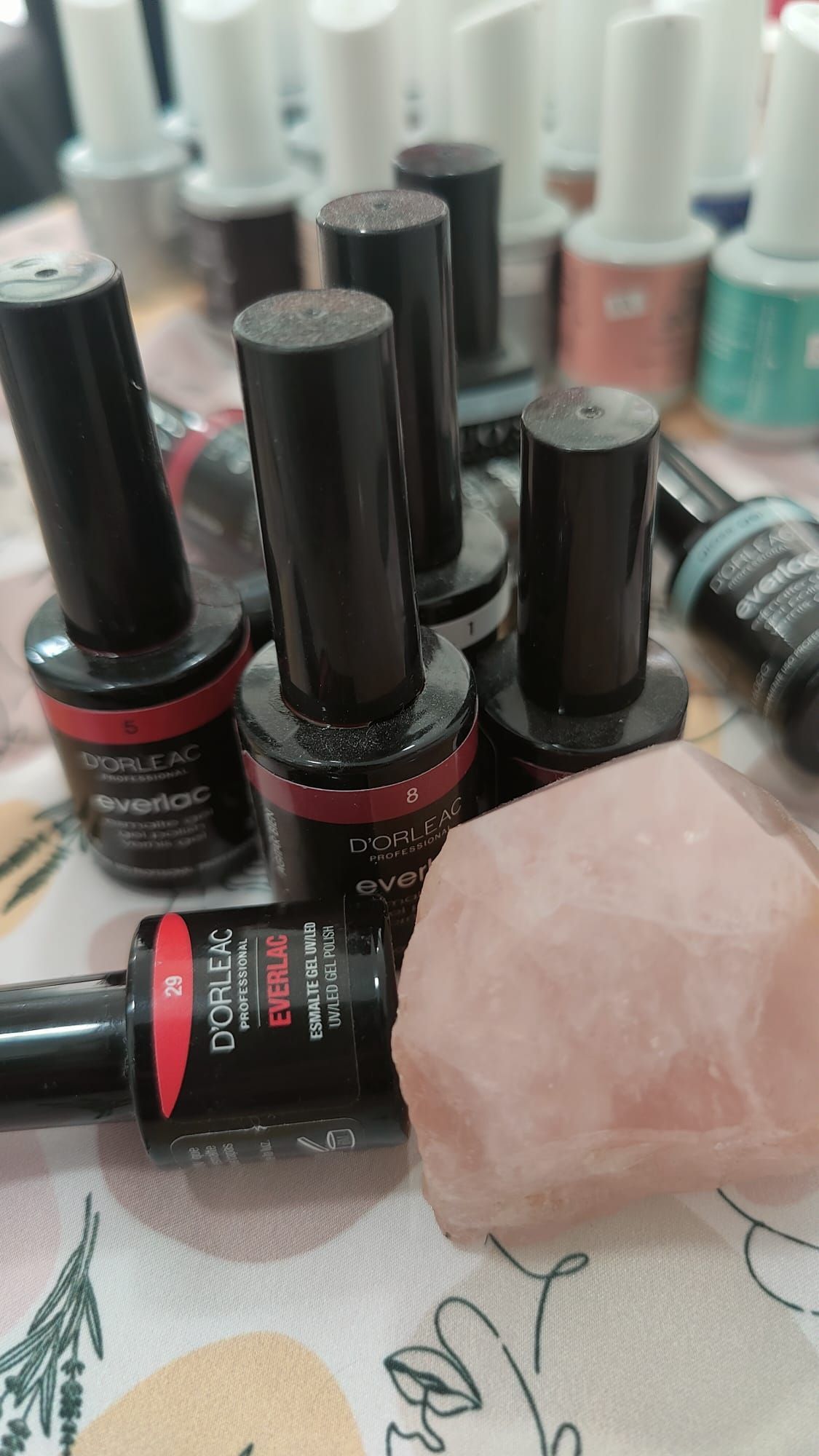 Un montón de botellas de esmalte de uñas colocadas una encima de otra sobre una mesa.