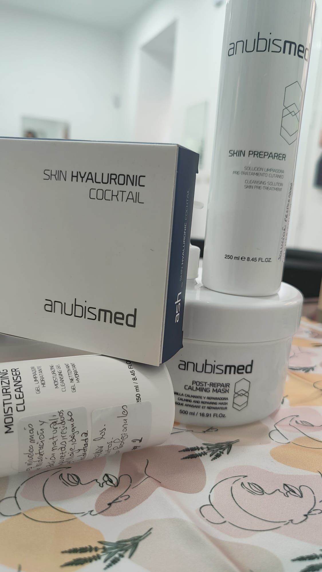 Una botella de loción y una caja de loción están sobre una mesa.