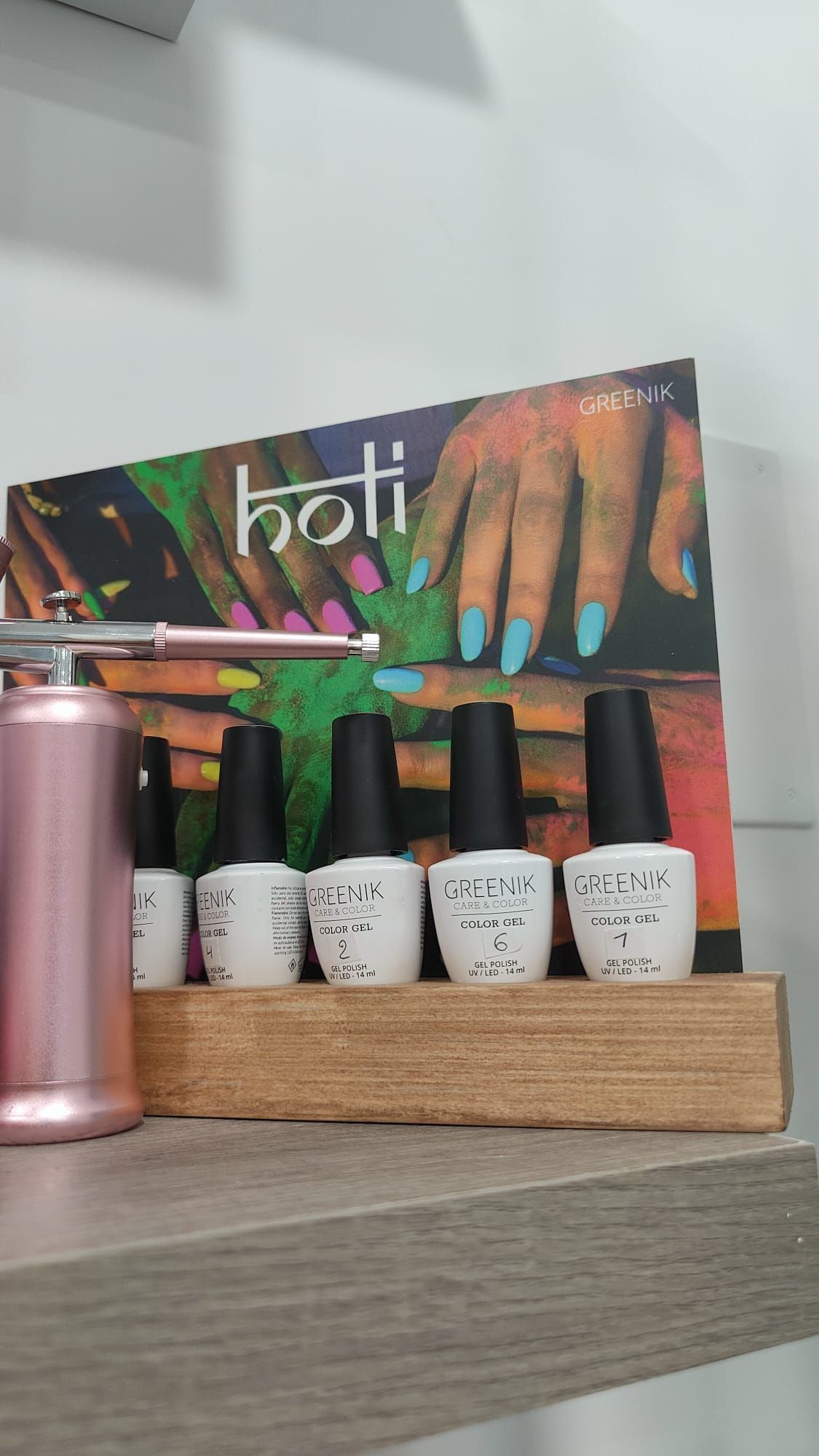 Una exhibición de esmaltes de uñas se encuentra en un estante de madera.