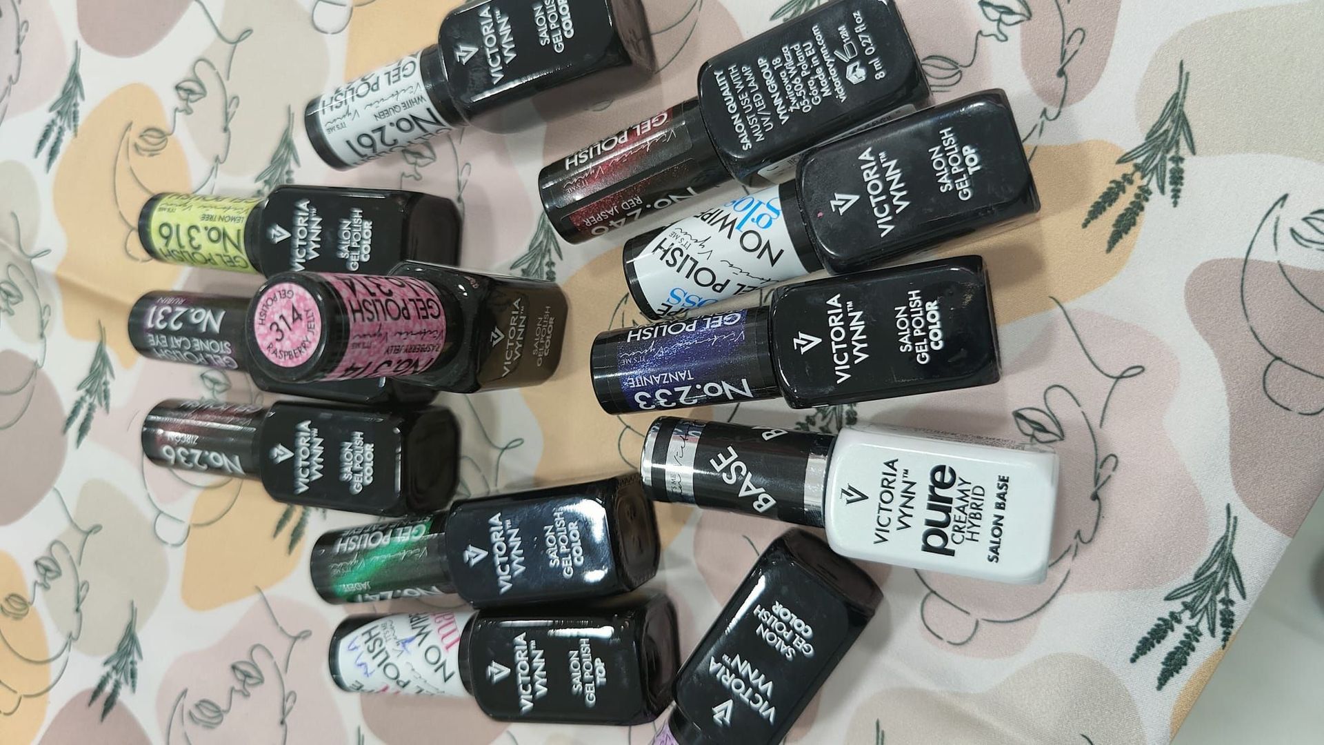 Un montón de botellas de esmalte de uñas están sobre una mesa.