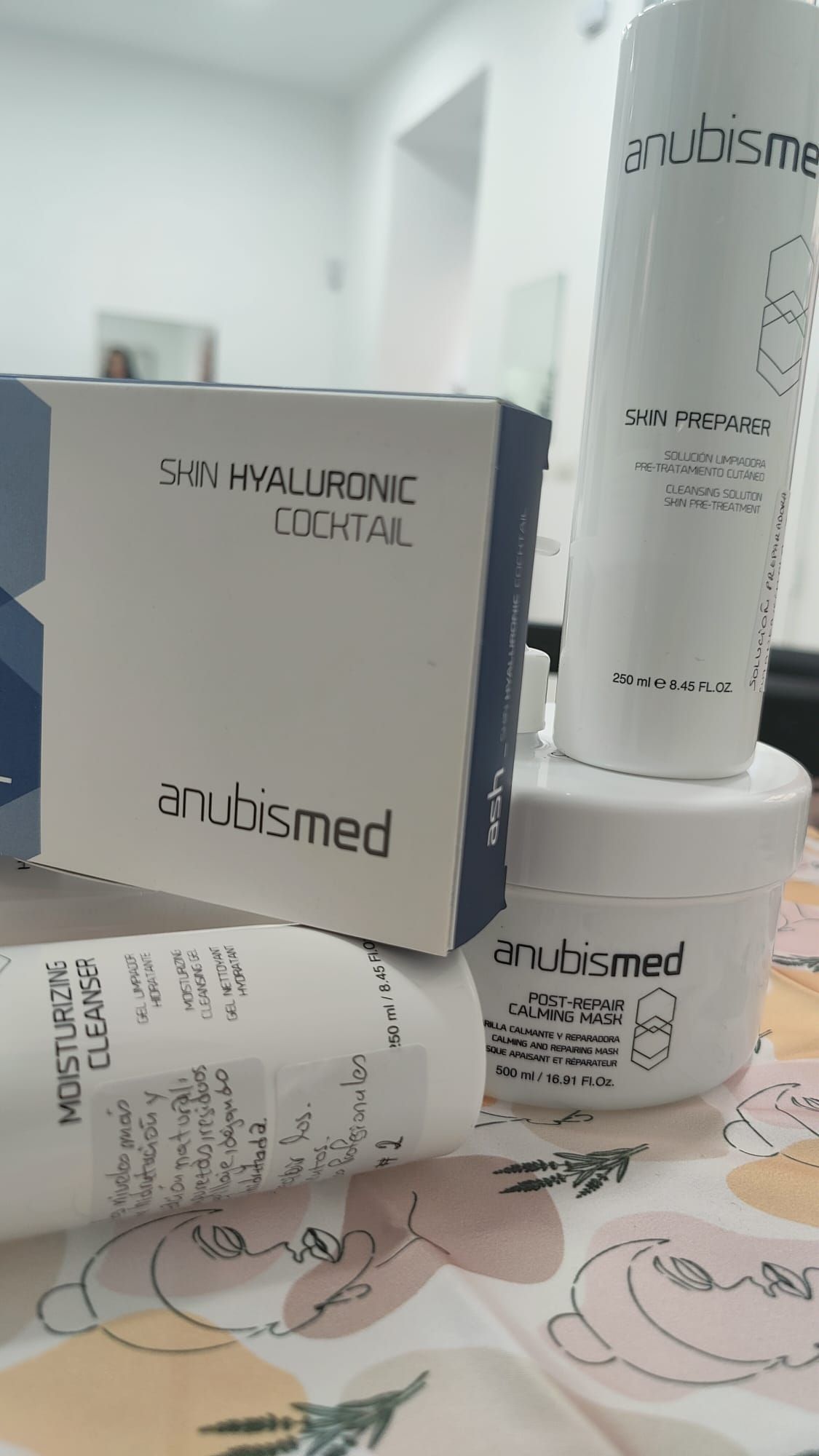 Una pila de botellas y cajas de cosméticos sobre una mesa.