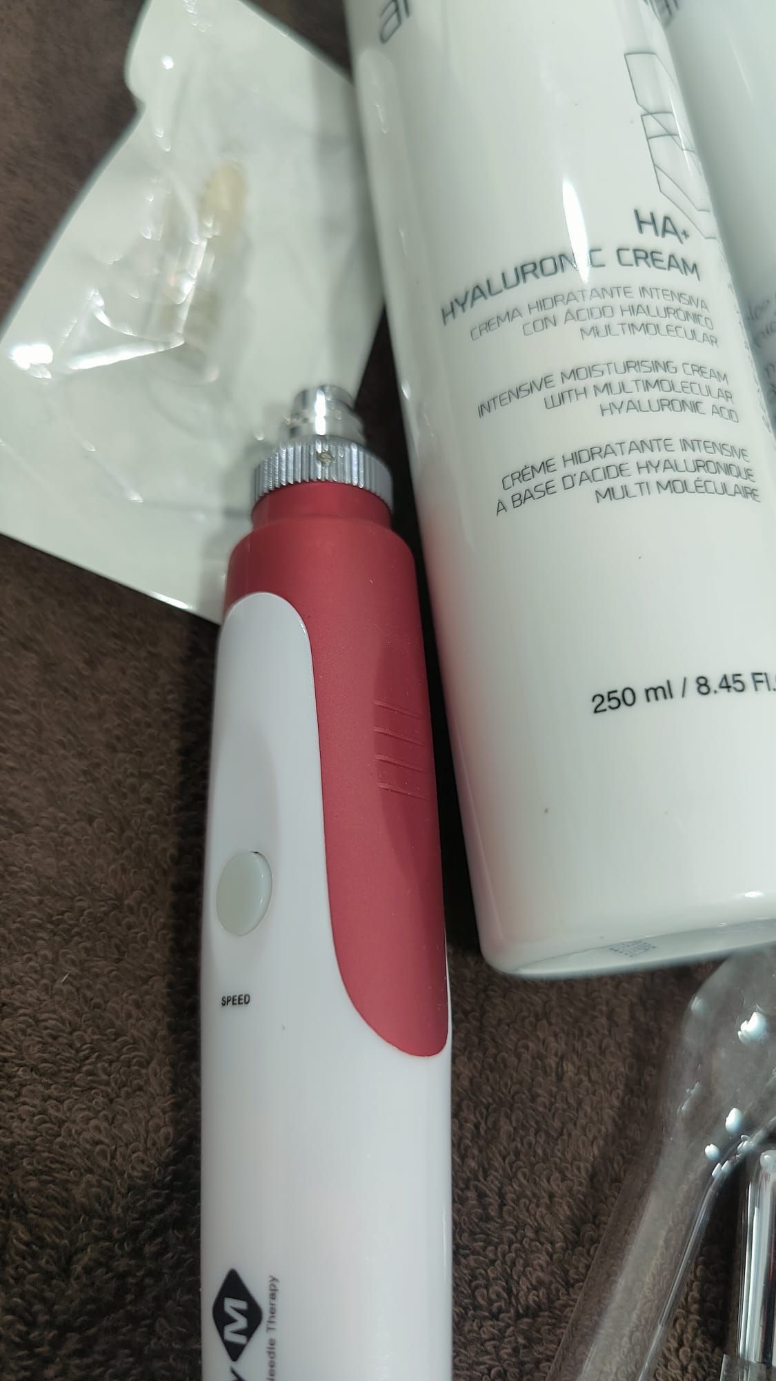 Un dispositivo rojo y blanco está al lado de una botella de loción.