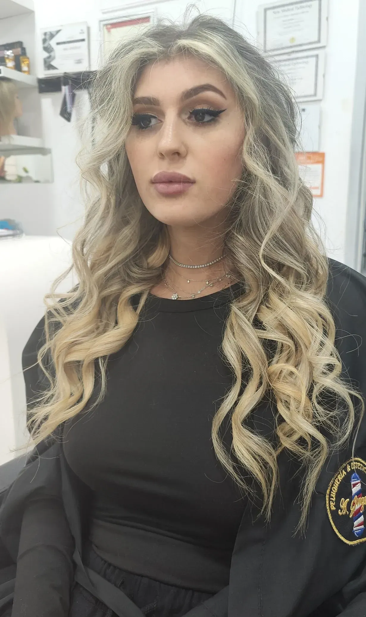 Una mujer con cabello largo y rubio lleva una camisa negra.