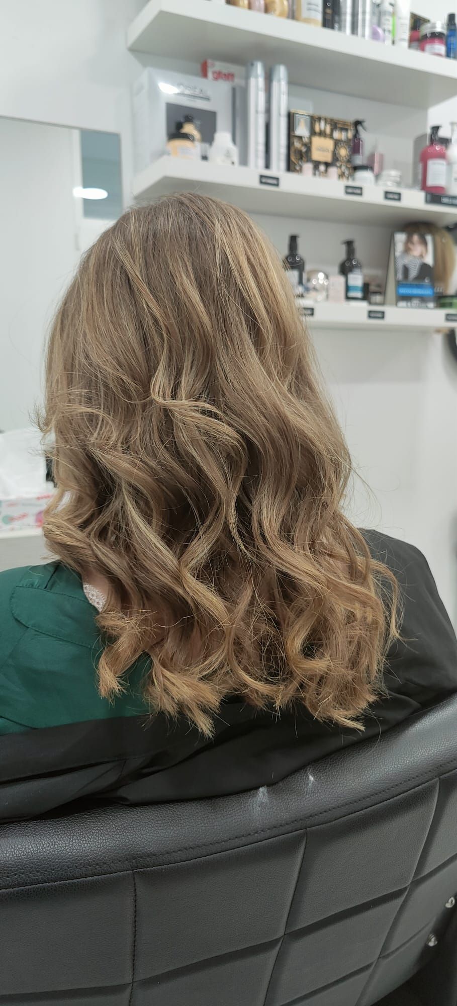 Una mujer está sentada en una silla con su cabello en un salón.