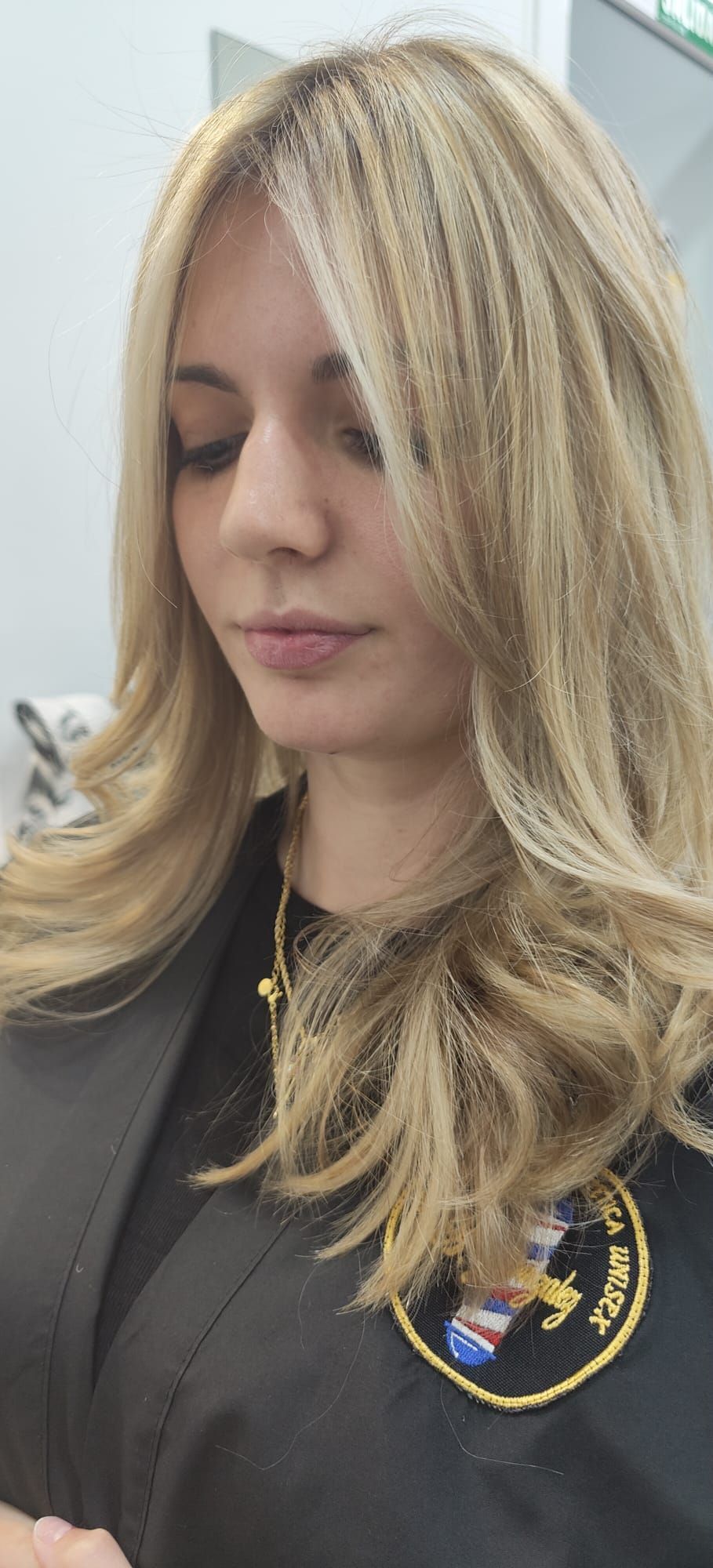 Una mujer con cabello largo y rubio lleva una chaqueta negra y una camisa negra.