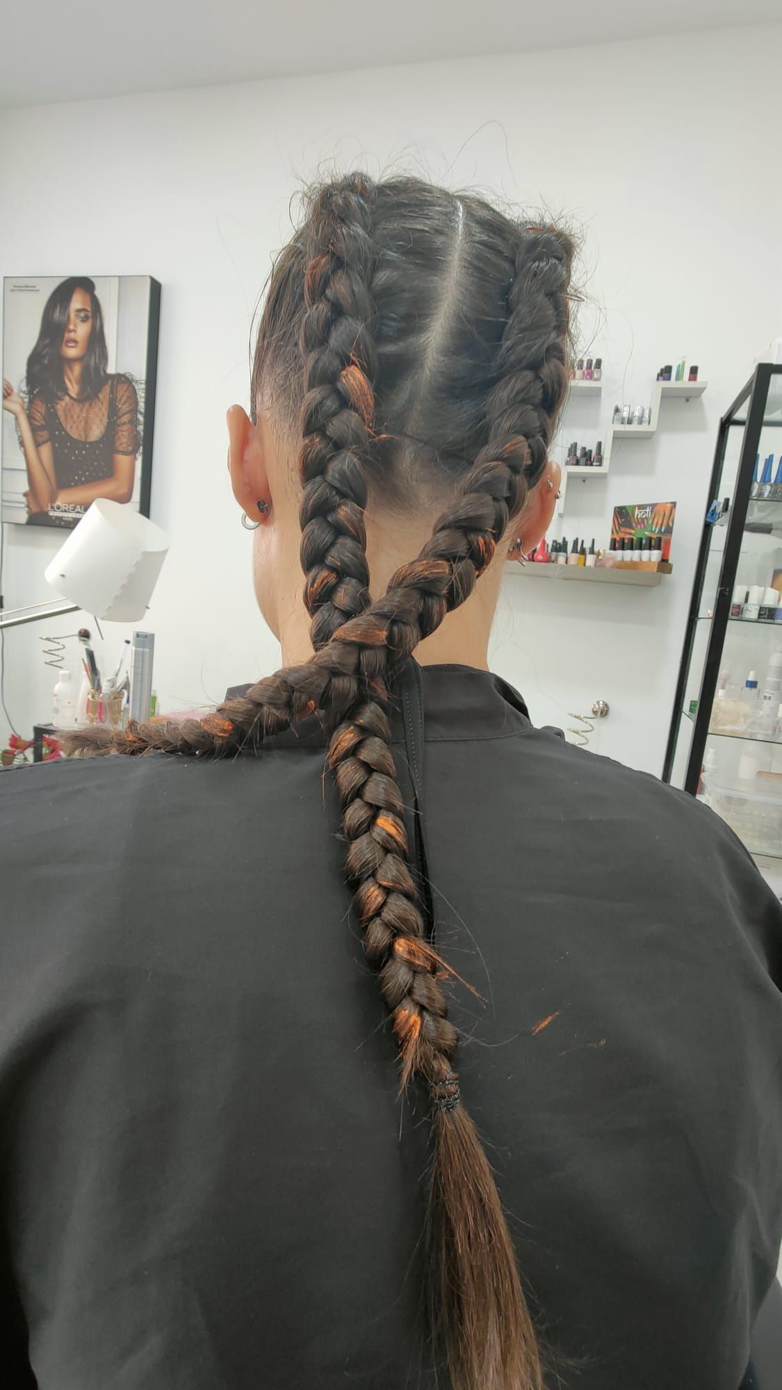 Una mujer con trenzas en el cabello está parada en una habitación.
